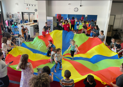 Rec kids playing with rainbow parachute